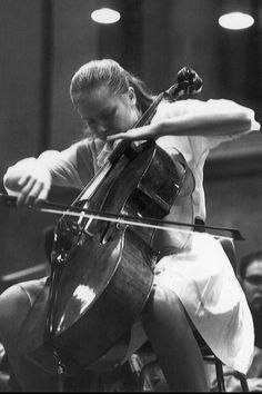 an old photo of a woman playing the cello