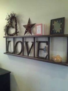 a shelf with some decorations on it and the word love spelled in cursive letters