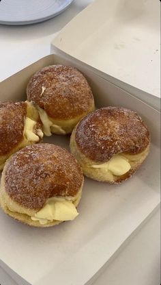 four pastries sitting in a box on top of a table