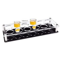 three shot glasses are sitting on top of a rack with four shots in it and one is