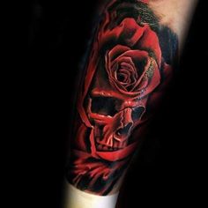 a man's arm with a red rose and skull tattoo on the left forearm