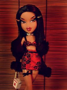 the doll is wearing a red dress and holding a handbag in her right hand