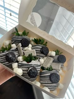 a box filled with cookies and marshmallows covered in black and white frosting