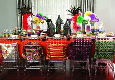 the table is set with many colorful chairs and place settings for people to sit at