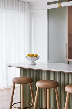 two stools in front of a counter with fruit on it