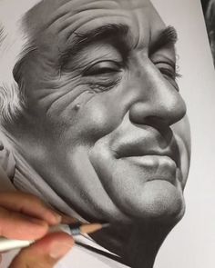 a drawing of an older man's face is being worked on with colored pencils