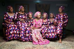 a group of women sitting next to each other on top of a carpeted floor