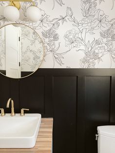 a white sink sitting under a mirror next to a toilet