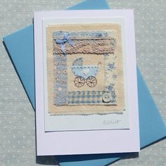 a card with a baby's carriage on the front and blue envelopes behind it