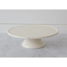 This farmhouse-inspired cake stand is perfect for your cottage kitchen. Enjoy your favorite desserts on this 9" diameter beaded-edge white cake stand- a great mix of modern and classic. Size: 3" H x 9" Dia Material: Dolomite Condition: New Beaded Cake Stand, Beaded Cake, Elegant Cake Stands, White Cake Stand, Painted Spoons, Rustic Dinnerware, Elegant Cake, Beautiful Cake Stands, Oak Cabinet