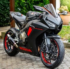 a black motorcycle parked on top of a brick road