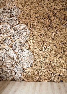 the wall is made out of rolled up paper and wood planks, with a wooden floor in front of it