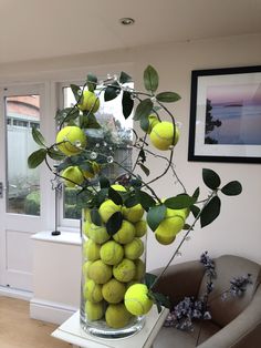 a vase filled with tennis balls sitting on top of a table