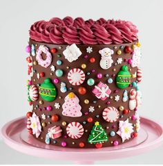 a decorated chocolate cake on a pink plate