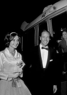 a man in a tuxedo standing next to a woman