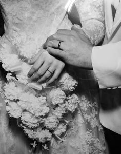 the bride and groom are holding each other's wedding bouquet in black and white