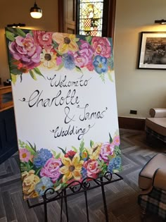 a welcome sign with flowers on it in front of a stained glass window