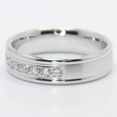 a white gold wedding ring with channeled diamonds on the side, set in 18k white gold