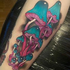 a colorful tattoo with mushrooms and flowers on it