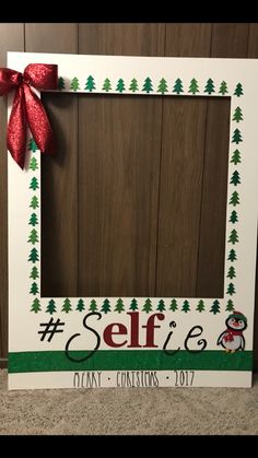 a white frame with a red bow on it and the word selfie painted on it