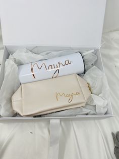 an open box containing two personalized items and a pair of gloves on the bed