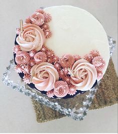 a white cake with pink frosting flowers on top