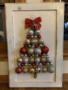 a christmas tree made out of ornaments in a frame