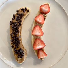 a banana split with chocolate chips and strawberries on it sitting on a white plate