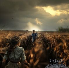 a man and woman walking through a wheat field