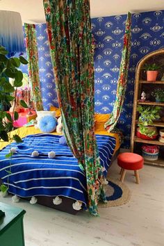 a bedroom with blue walls and colorful curtains