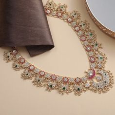 Description A stunning mélange of Mughal motifs from the north with guttapusallu style from southern India, Mahnaz is a handcrafted heirloom necklace, perfect for celebrations. Falling long, the piece features floral nuances and iconic crescents that meet at a lotus bud. Pink and green kempu stones along with uncut polkhis are set in Jadau style, accentuated by a pearl border. Clusters of rice pearls add traditional fervor to this necklace bearing testament to the artistic prowess of our artisan Elegant Navratri Jewelry With Motifs, Festive Long Kundan Necklace With Tilla Detail, Navratri Chandbali Necklaces, Traditional Long Temple Necklace For Celebration, Navratri Festive Chandbali Necklaces, Festive Chandbali Necklaces For Celebration, Tilla Temple Jewelry Necklace For Celebration, Festive Chandbali Necklaces For Diwali, Temple Jewelry Tilla Necklace For Celebrations