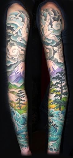 tattoos on both arms with trees and clouds in the sky above them, as well as water