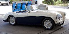 an old car is parked in front of a gas pump