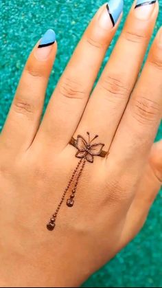 a woman's hand with a bow on it and a tattoo on the ring