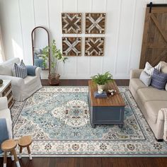 a living room filled with furniture and decor on top of a hard wood floored floor