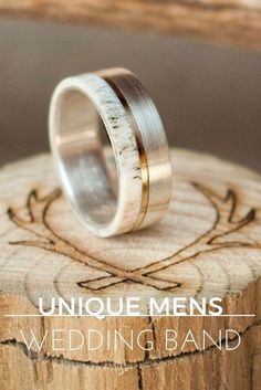 the unique men's wedding band is on top of a piece of wood