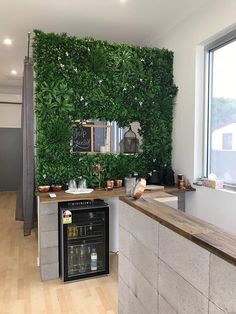 a kitchen with a large green wall behind the counter and sink area, next to a window