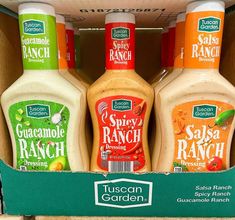 three bottles of salad ranch sitting in a cardboard box