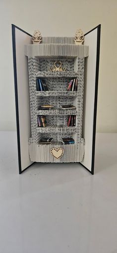 an open book with bookshelves made out of paper and some other things on it