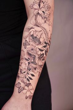 a woman's arm with flowers and butterflies on it