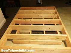 a wooden bed frame sitting on top of a carpeted floor