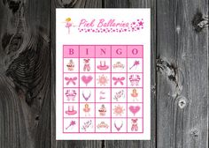 a pink and white card with the words pink ballerinas on it, sitting next to a wooden fence