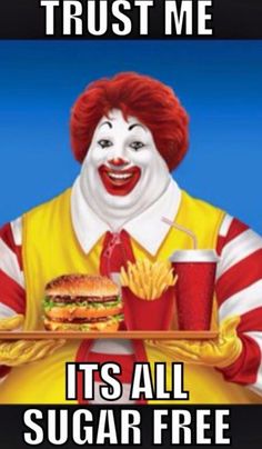 a clown holding a tray with a burger and fries on it, says trust me it's all sugar free