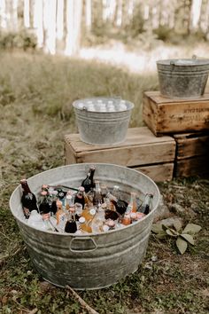 two buckets full of beer bottles sitting on the ground