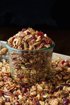 a glass jar filled with granola sitting on top of a table next to another container full of granola