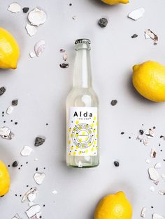 an empty bottle next to some lemons and broken glass on a white surface with confetti scattered around it