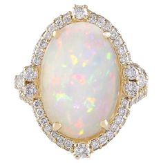 Introducing our exquisite 7.09 Carat Opal 14K Yellow Gold Diamond Ring, a stunning blend of luxury and elegance. 8.25 Carat Opal 14K Yellow Gold Diamond Ring Stamped: 14K Yellow Gold Total Ring Weight: 8 Grams Opal Weight is 6.80 Carat (Measures: 16.00x12.00 mm) Diamond Weight is 1.45 Carat Color: F-G, Clarity: VS2-SI1 Face Measures: 23.20x20.30 mm Sku: [704112W] Opal Diamond Ring, Cowry Shell, Yellow Gold Diamond Ring, Modern Engagement Rings, Zero Tolerance, Fine Jewelery, Gold Diamond Ring, Opal Ring, Gold Diamond Rings