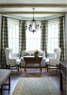 a living room filled with furniture and a chandelier hanging from the side of a window