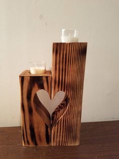 a wooden block with a heart cut out of it and a candle holder in the shape of a log