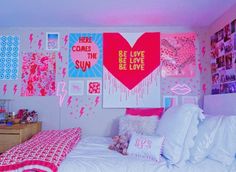 a bedroom decorated in pink and white with pictures on the wall, bedding and pillows